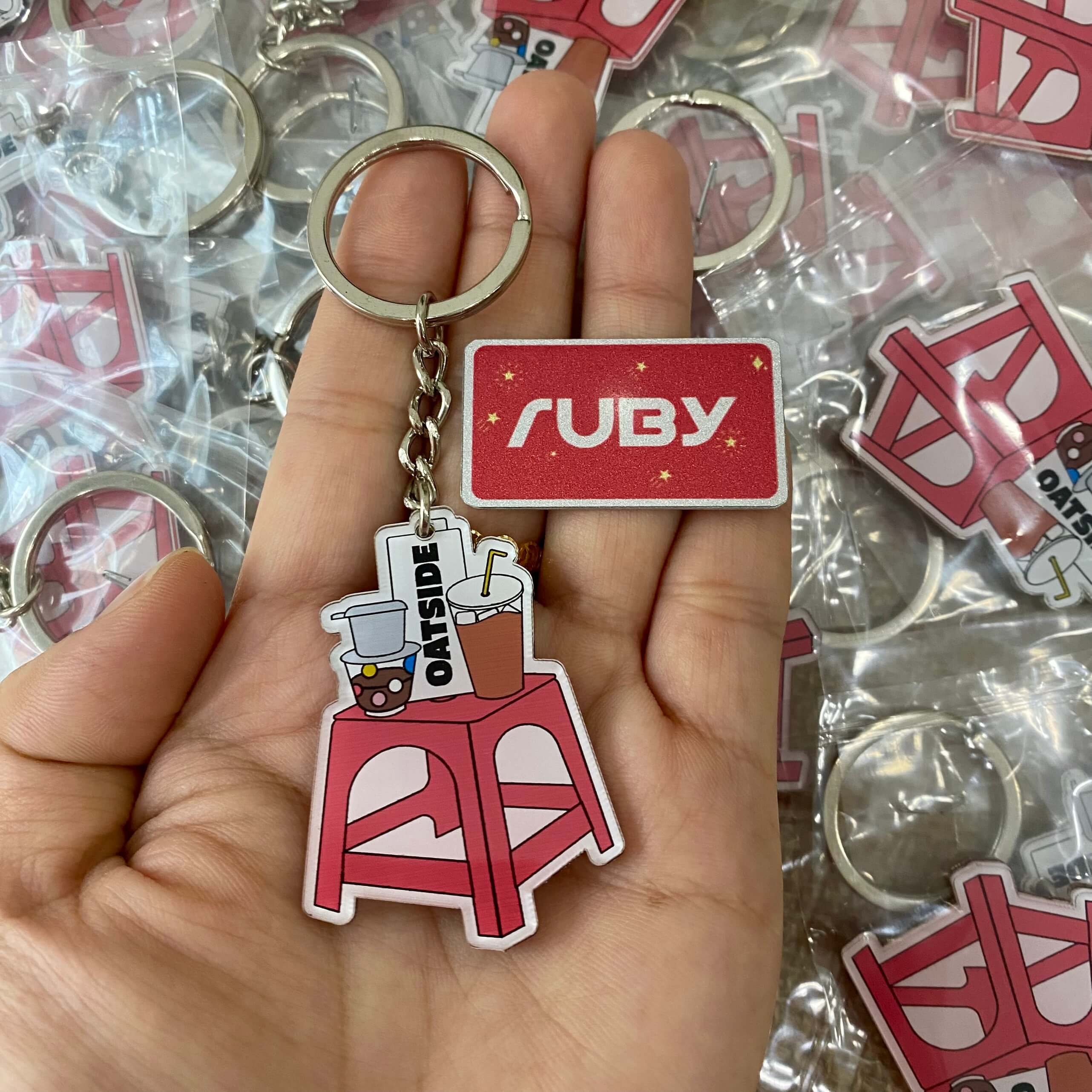 Móc khóa Oatside hình ghế nhựa đỏ kèm đồ uống, mô phỏng văn hóa vỉa hè Việt Nam, sản xuất tại xưởng Ruby