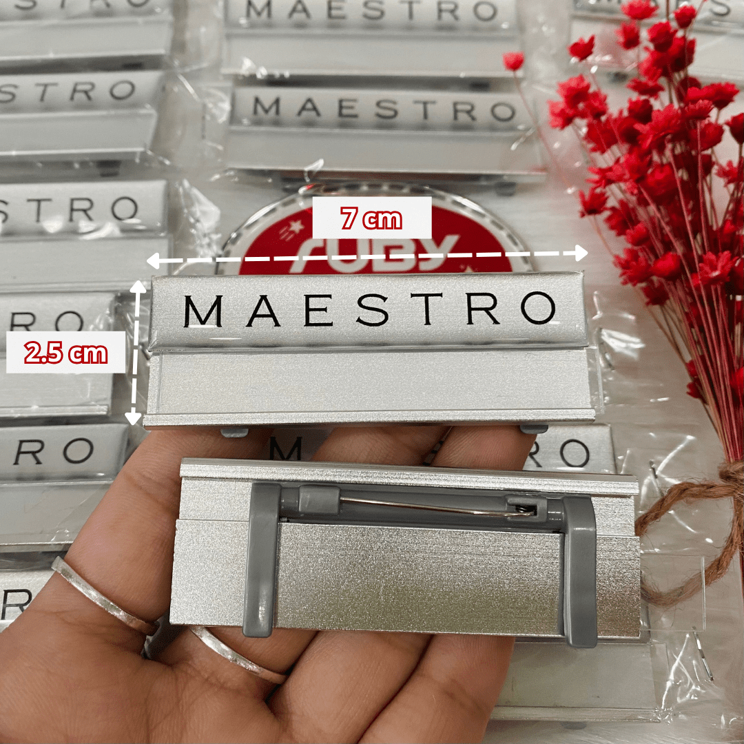 Hình ảnh chi tiết kích thước chuẩn 7x2.5 cm của mẫu bảng tên thay tên MAESTRO làm bằng phôi nhôm nền bạc.