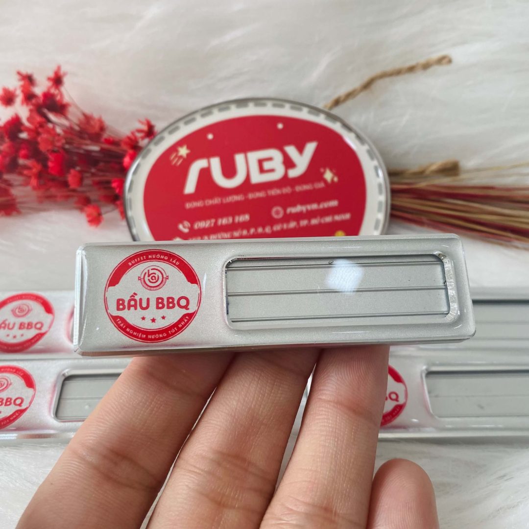 Bảng tên nhân viên Bầu BBQ, in logo đỏ, có khe thay tên tiện lợi