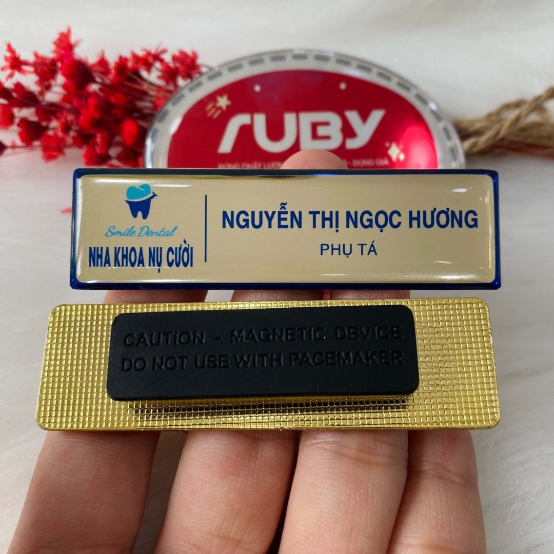 Bảng tên nha khoa Nụ Cười nền màu kem, viền xanh, in logo