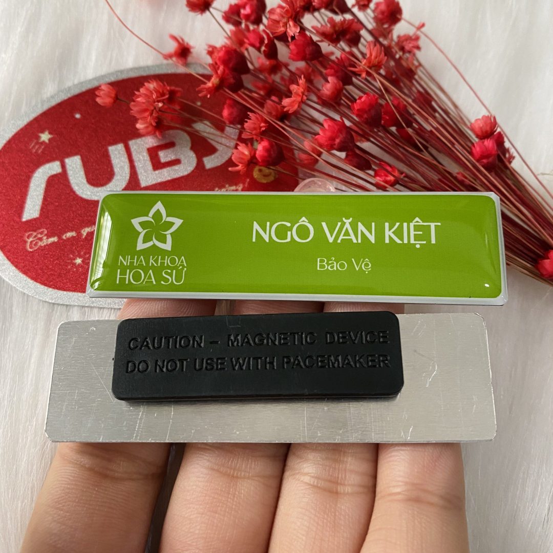 Bảng tên nhân viên nha khoa nhôm màu xanh lá, in logo Nha Khoa Hoa Sứ