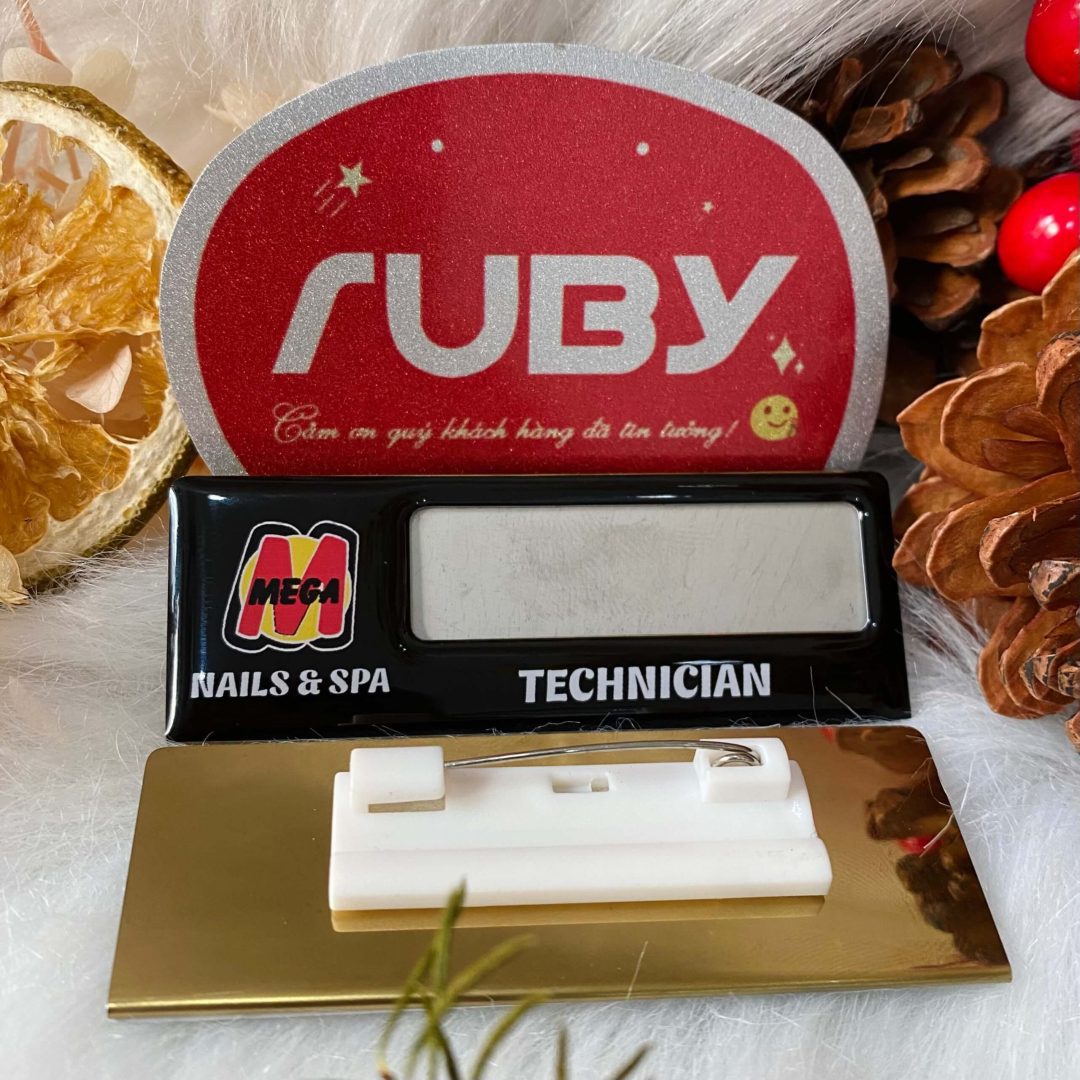 Bảng tên nhân viên Mega Nails & Spa inox, in nền đen bóng, logo M đỏ vàng, chữ Technician trắng.