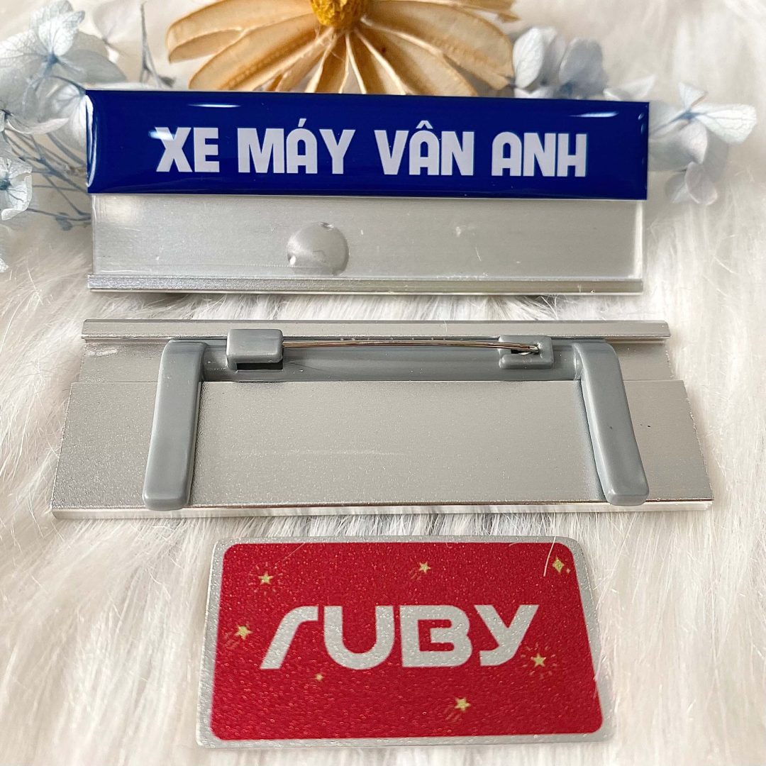 Bảng tên Xe Máy Vân Anh màu xanh, in chữ trắng, mặt sau có kim gài áo.