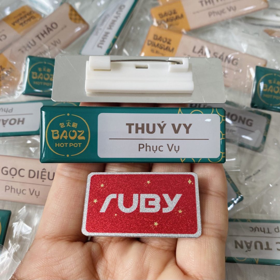 Bảng tên nhân viên nhà hàng Baoz Hotpot màu xanh rêu, in logo và tên