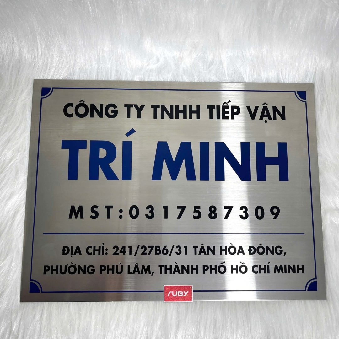 Bảng công ty inox TRÍ MINH ăn mòn logo và chữ xanh đậm trên nền bạc sáng