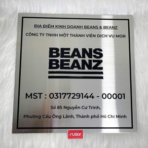 Bảng công ty inox BEANS BEANZ nền bạc, chữ đen ăn mòn, phong cách tối giản hiện đại