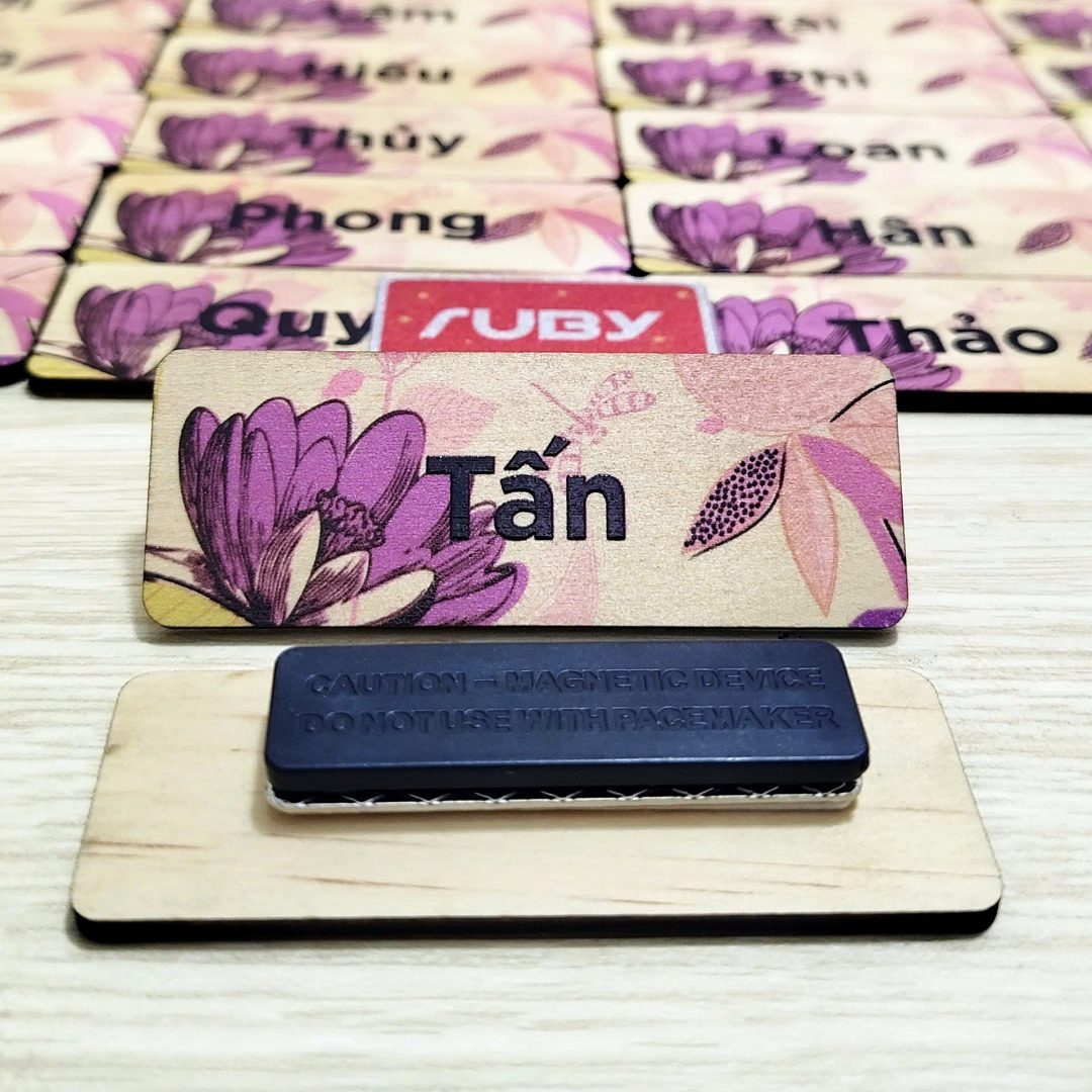Bảng tên nhân viên bằng gỗ có hoa văn tím, kèm nam châm gắn áo tiện lợi, thiết kế hiện đại và tinh tế.